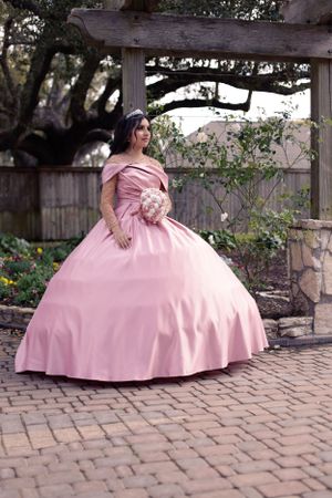 Sweet sixteen outdoor session/portrait of model wearing a pink dress and trees as background.