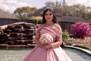 sweet sixteen outdoor portraitstanding in front of a water cascade.