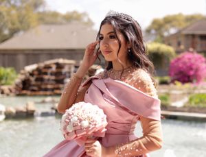 Sweet sixteen portrait and water fountain behind her with her lovely pink dress.