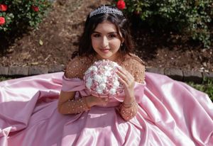 Sweet sixteen outdoor session/portrait of model sitting on the ground holding her bouquet smiling.
