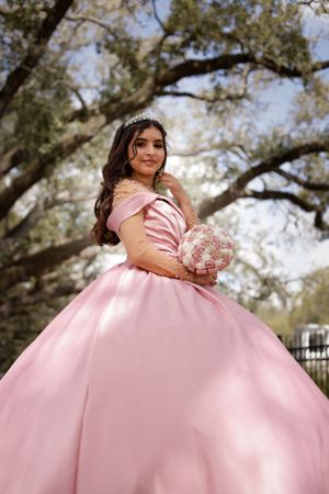 Sweet sixteen outdoor session/portrait of model under a canopy of tree in her pink dress.