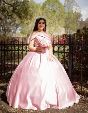 Sweet sixteen outdoor session/portrait of model in front of the fence with her pink dress and bouquet.