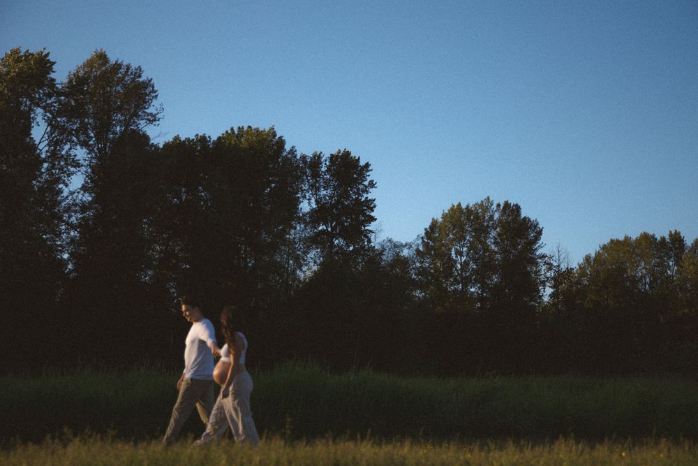 golden hour capture of a couple expecting their first child and walking along the tree line during an outdoor vancouver maternity session.