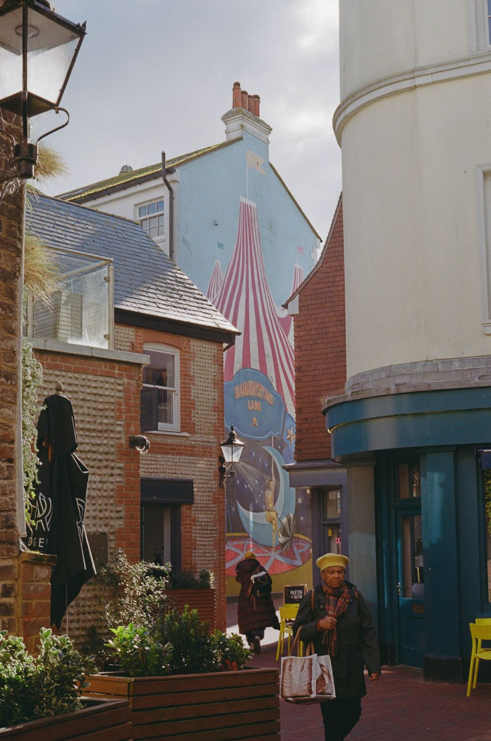 Colorful street art mural adorns the side of a building in a quaint neighborhood.