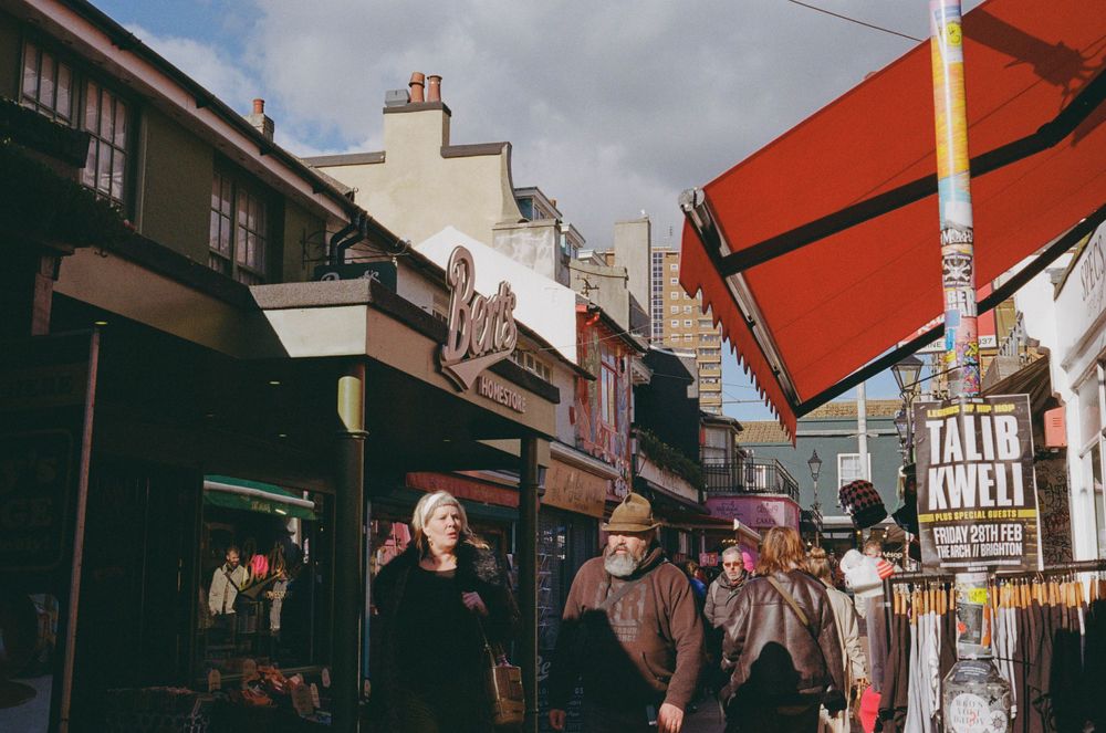 Bustling street scene in Brighton's historic shopping district with vintage storefronts and signs.