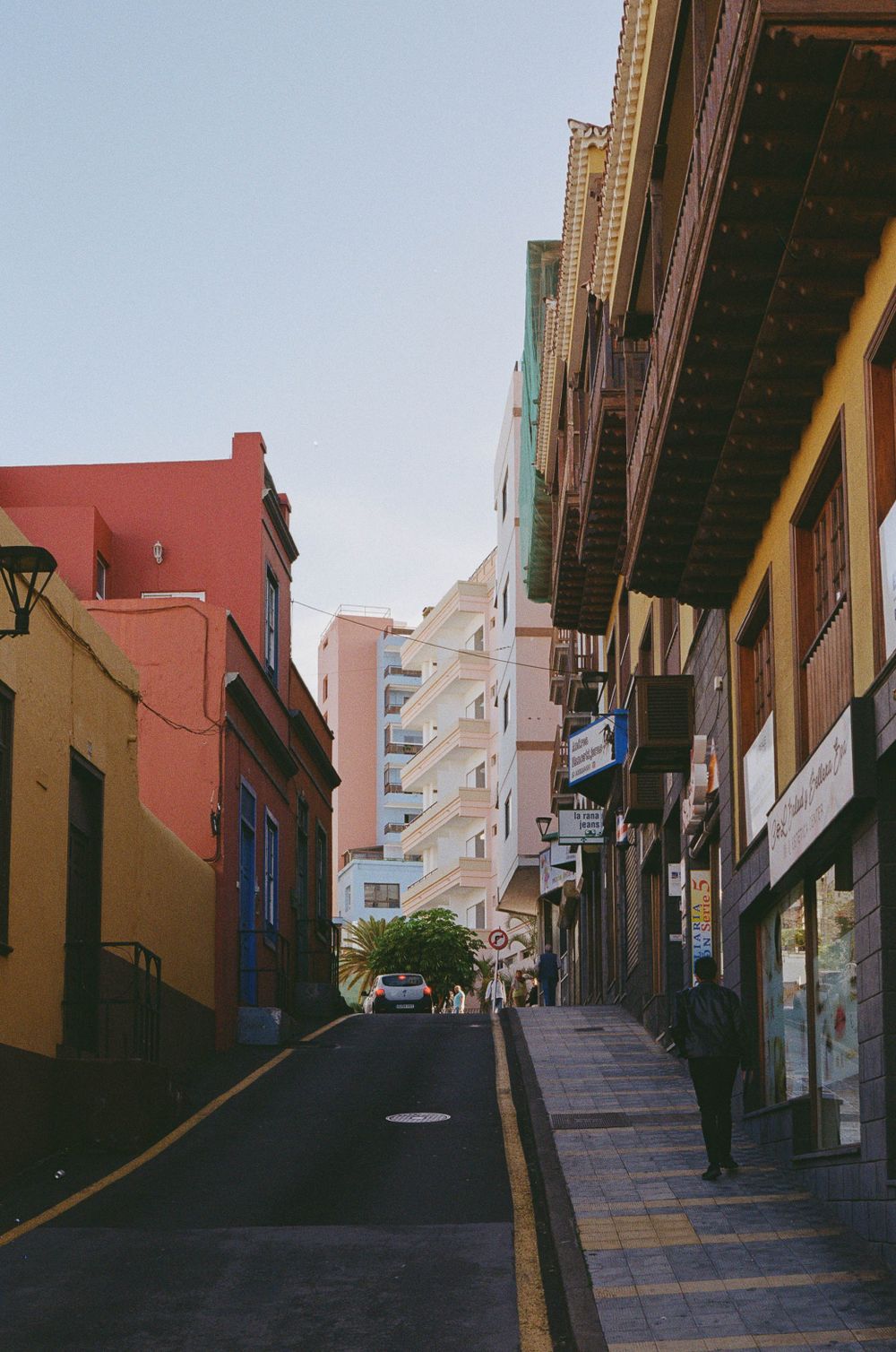 Colorful narrow street with traditional architecture and tall buildings in a Spanish colonial town.