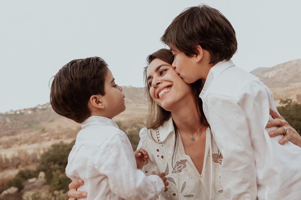 Candid outdoor family moment showing affectionate interaction in warm lighting.