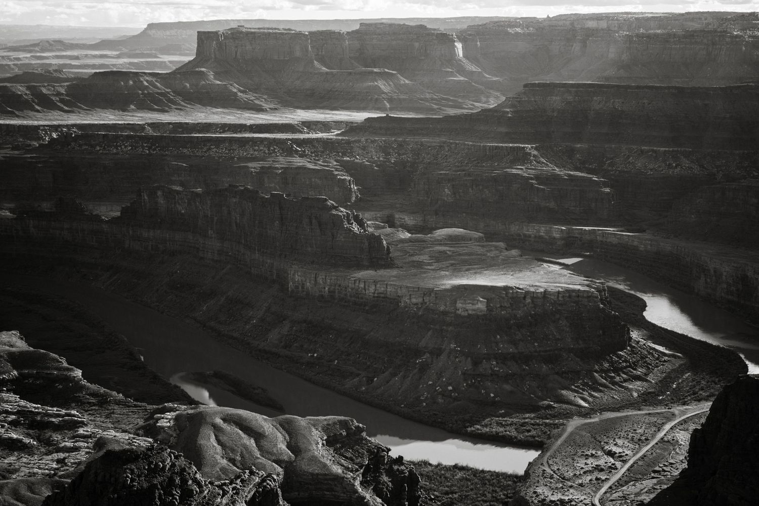 Bird's eye view of the Colorado River winding through steep canyon walls in monochrome.