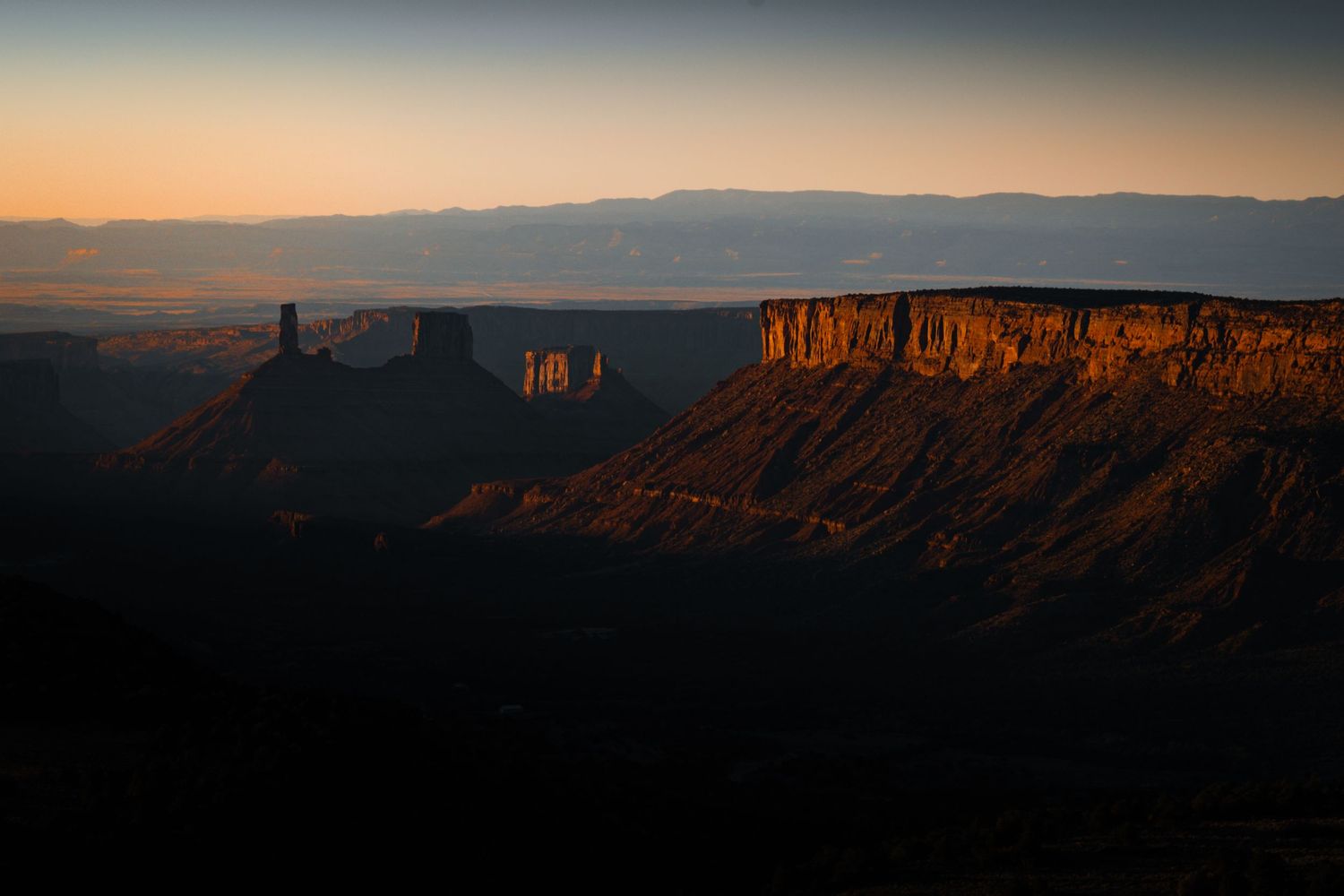 Sunset illuminates towering red cliffs and mesas in castle valley Utah.