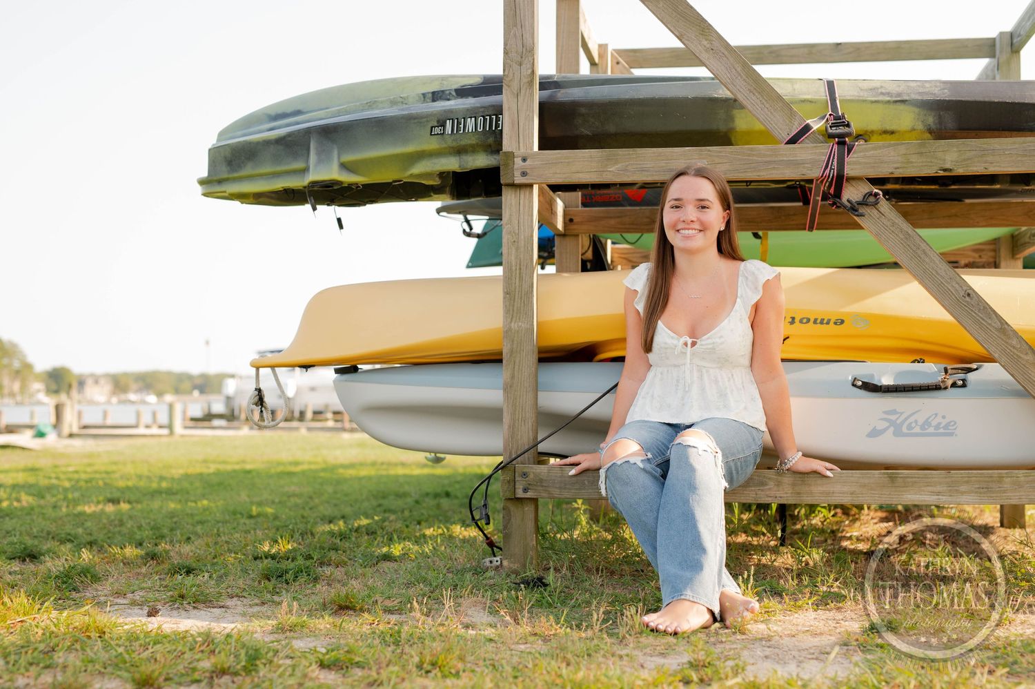 A casual portrait by kayak and canoe storage racks on a sunny day.