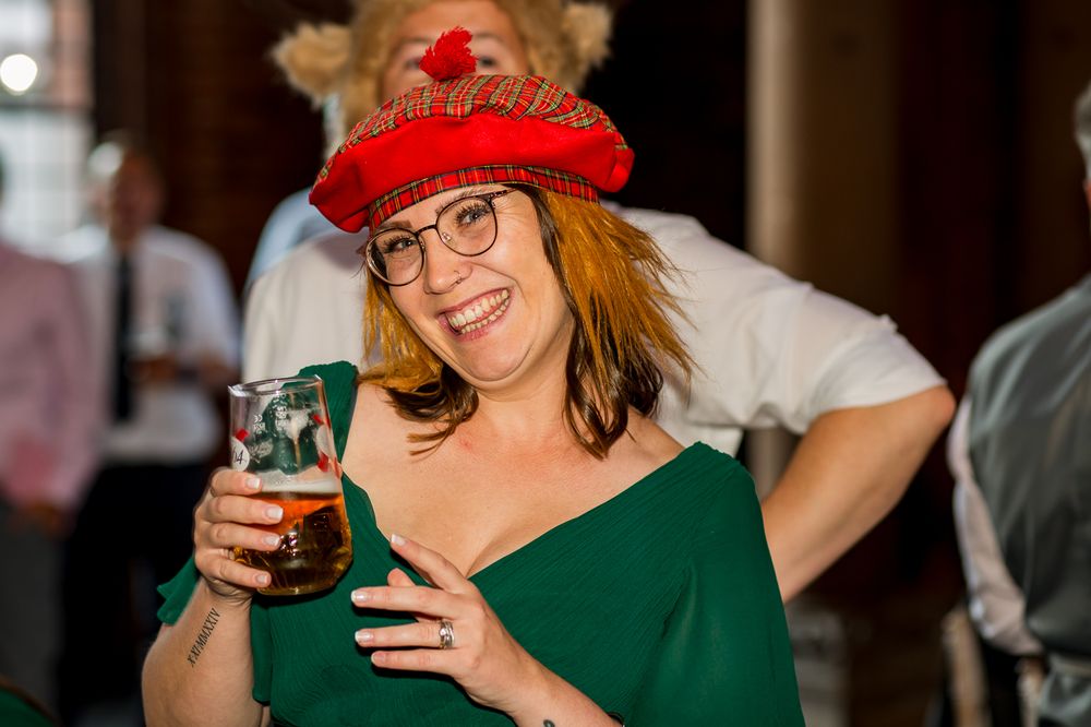 Wedding guests in festive attire enjoying drinks and conversation at reception.