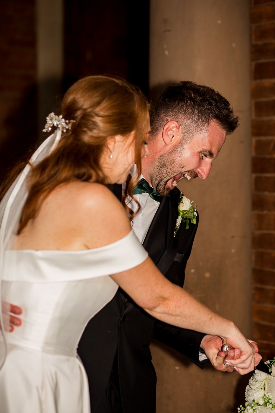 Couple sharing intimate moment during wedding cake cutting ceremony.