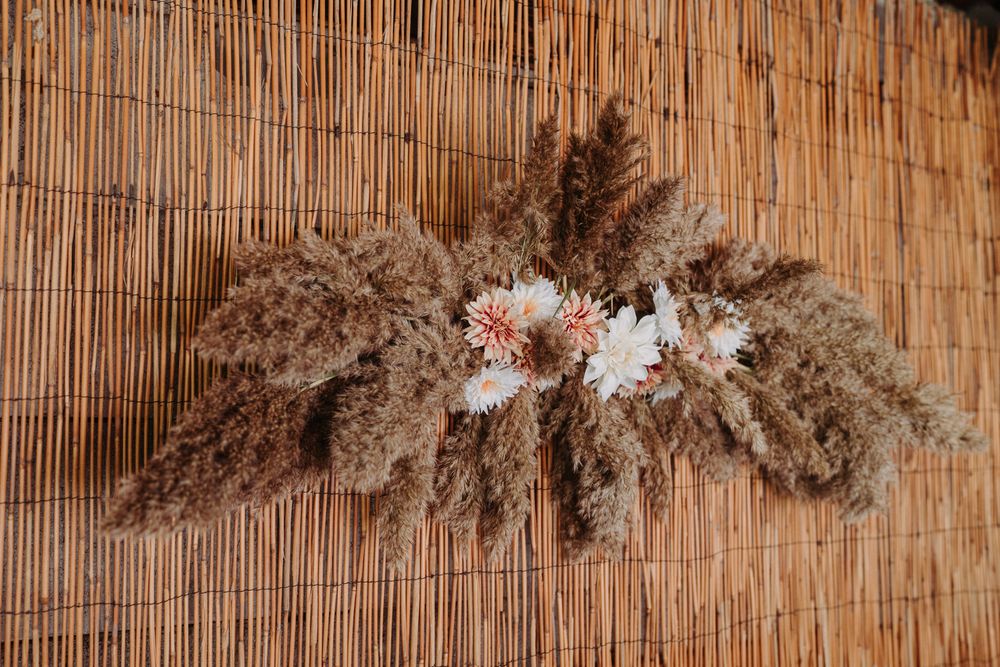 Natural dried pampas grass and bamboo decorative wall hanging with neutral tones.