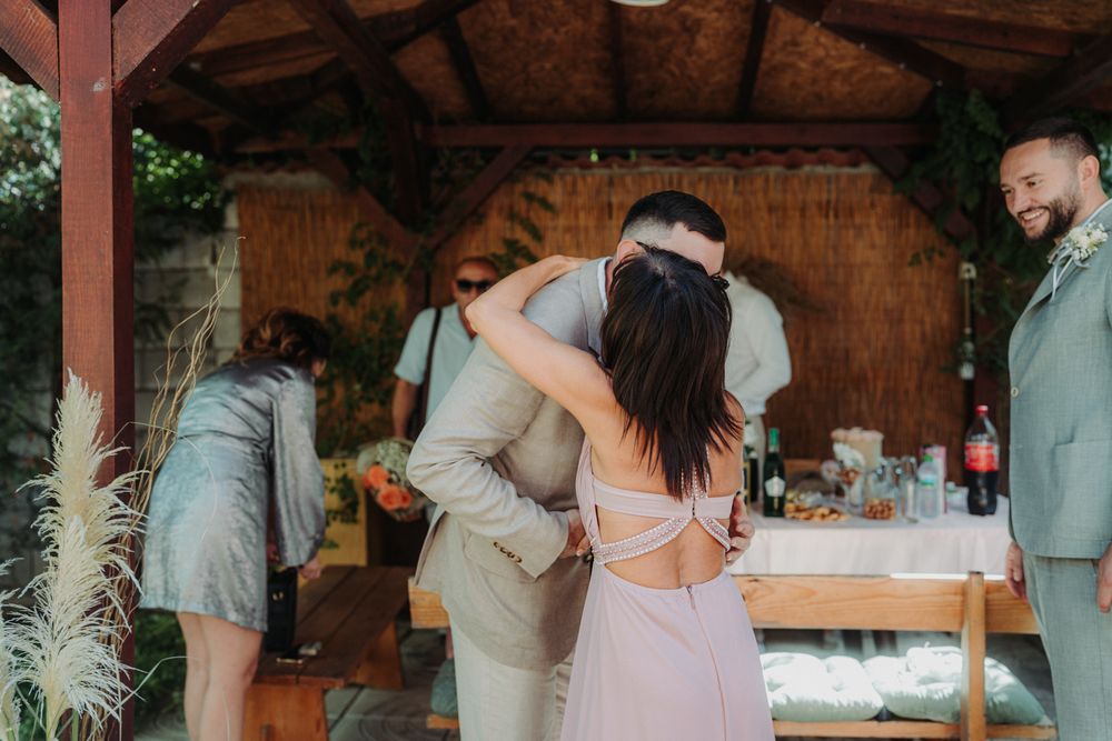 Wedding reception scene with guests mingling under covered outdoor venue.