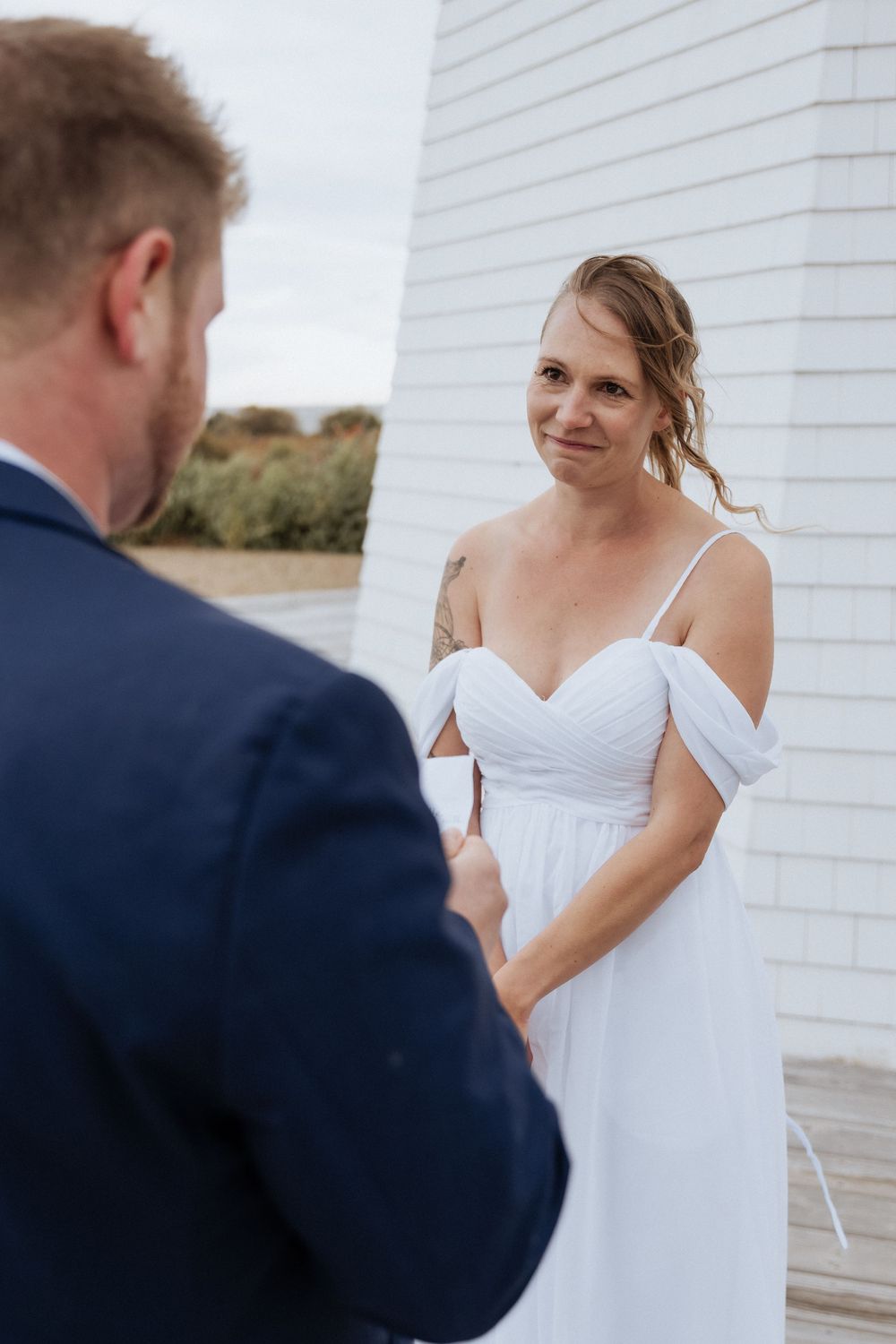 Bride and groom exchange vows in front of a lighthouse in New Brunswick, fall October wedding photography Moncton elopement portraits