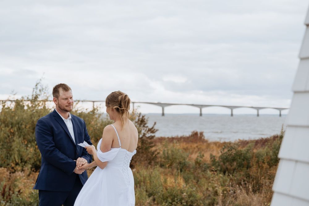 Bride and groom read vows during coastal wedding ceremony in New Brunswick, fall October wedding photography at Confederation Bridge PEI