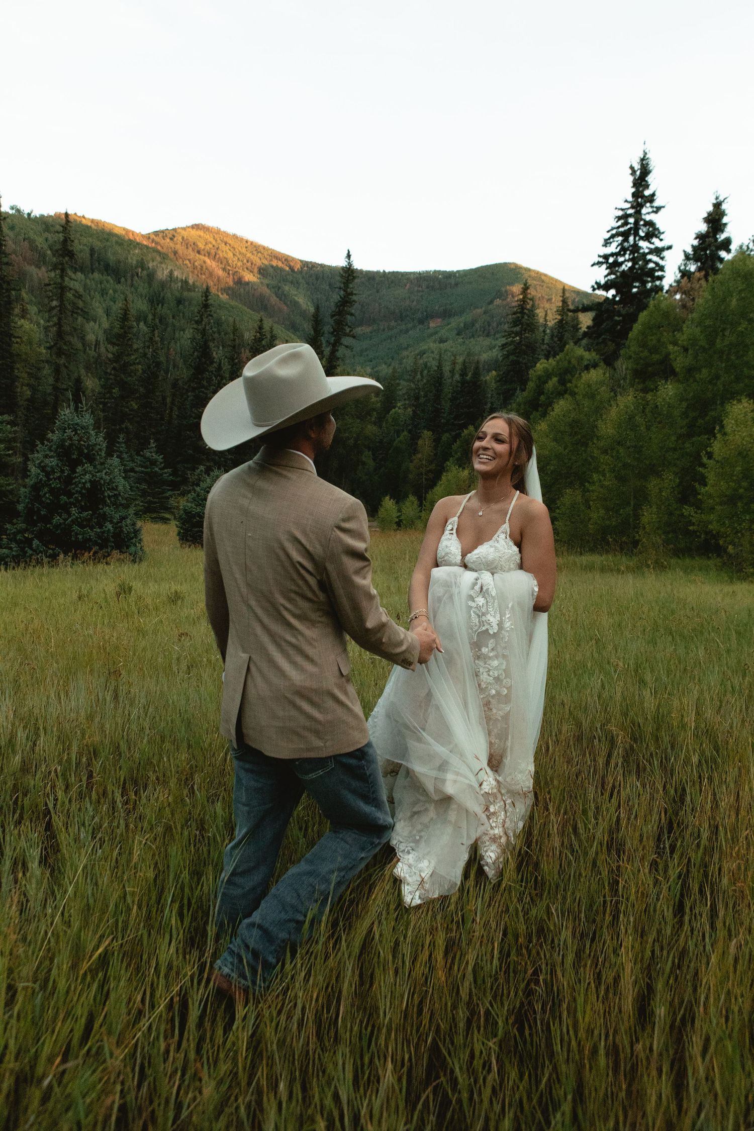 Bride leads groom through field
