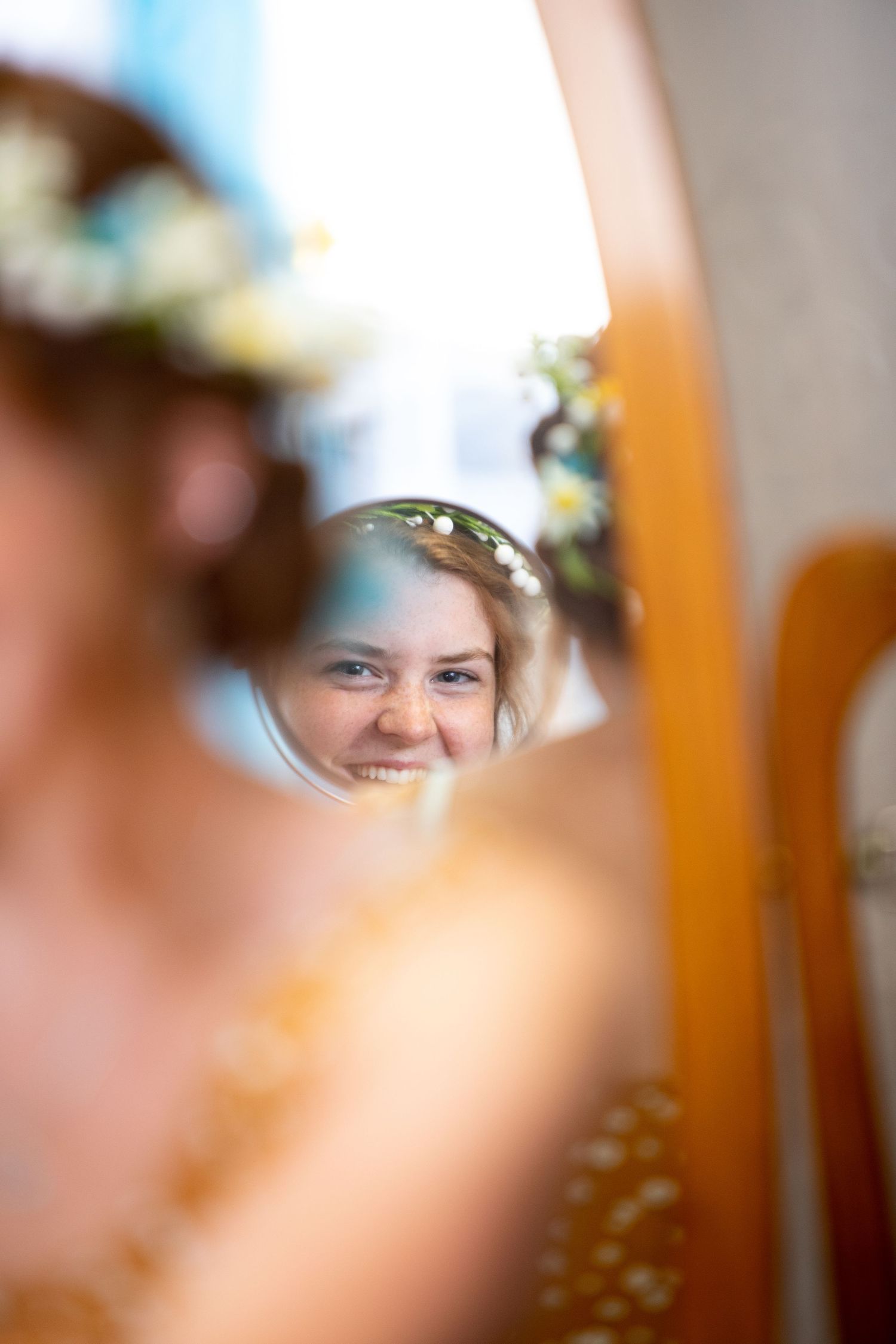 A reflection appears in a circular mirror with a soft bokeh effect and warm lighting in the background.
