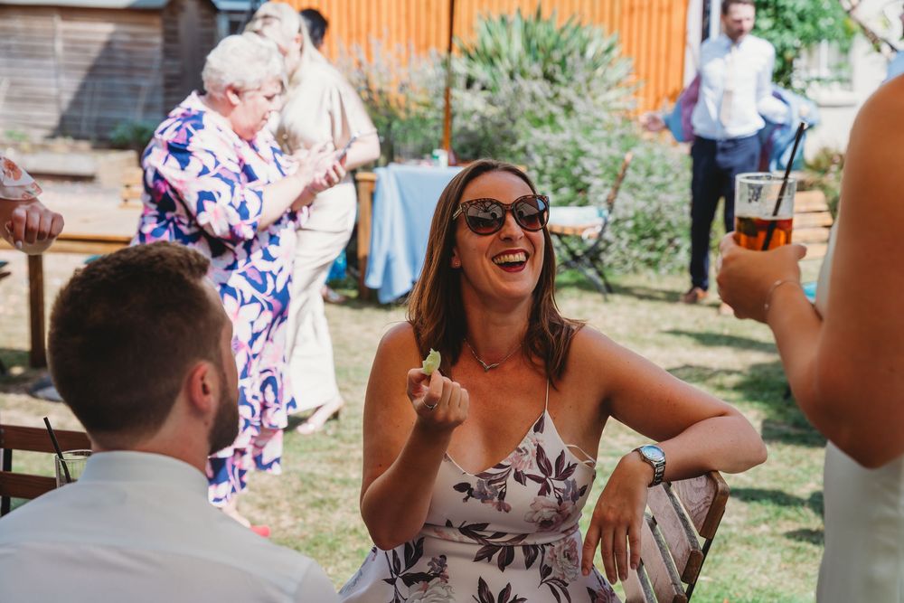 Guests enjoying a lively conversation at an outdoor wedding reception.