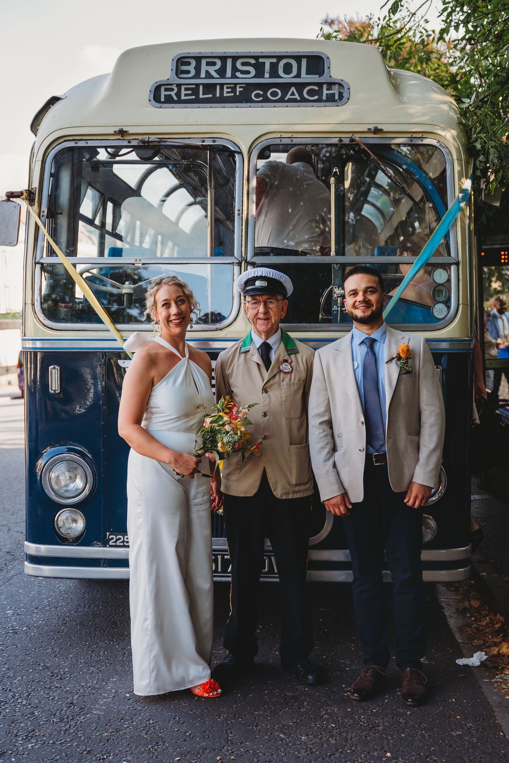 Wedding party posing in front of vintage Bristol coach buses.