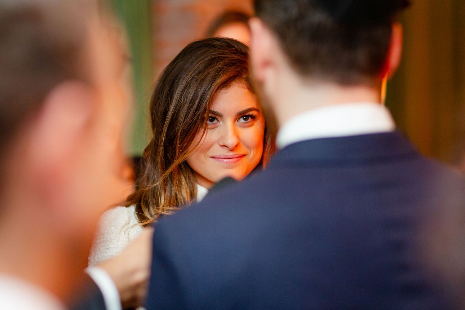 Candid wedding moment captured in warm ambient lighting with soft focus and romantic atmosphere.
