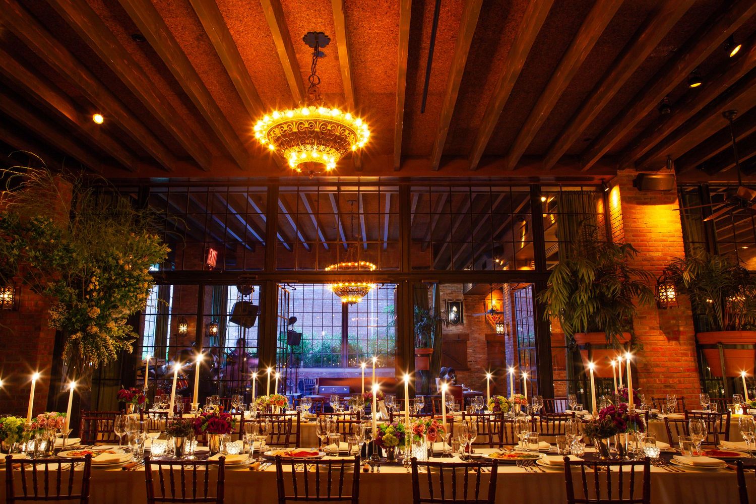 Elegant rustic wedding reception venue with exposed wooden beams and warm lighting creating a romantic atmosphere.