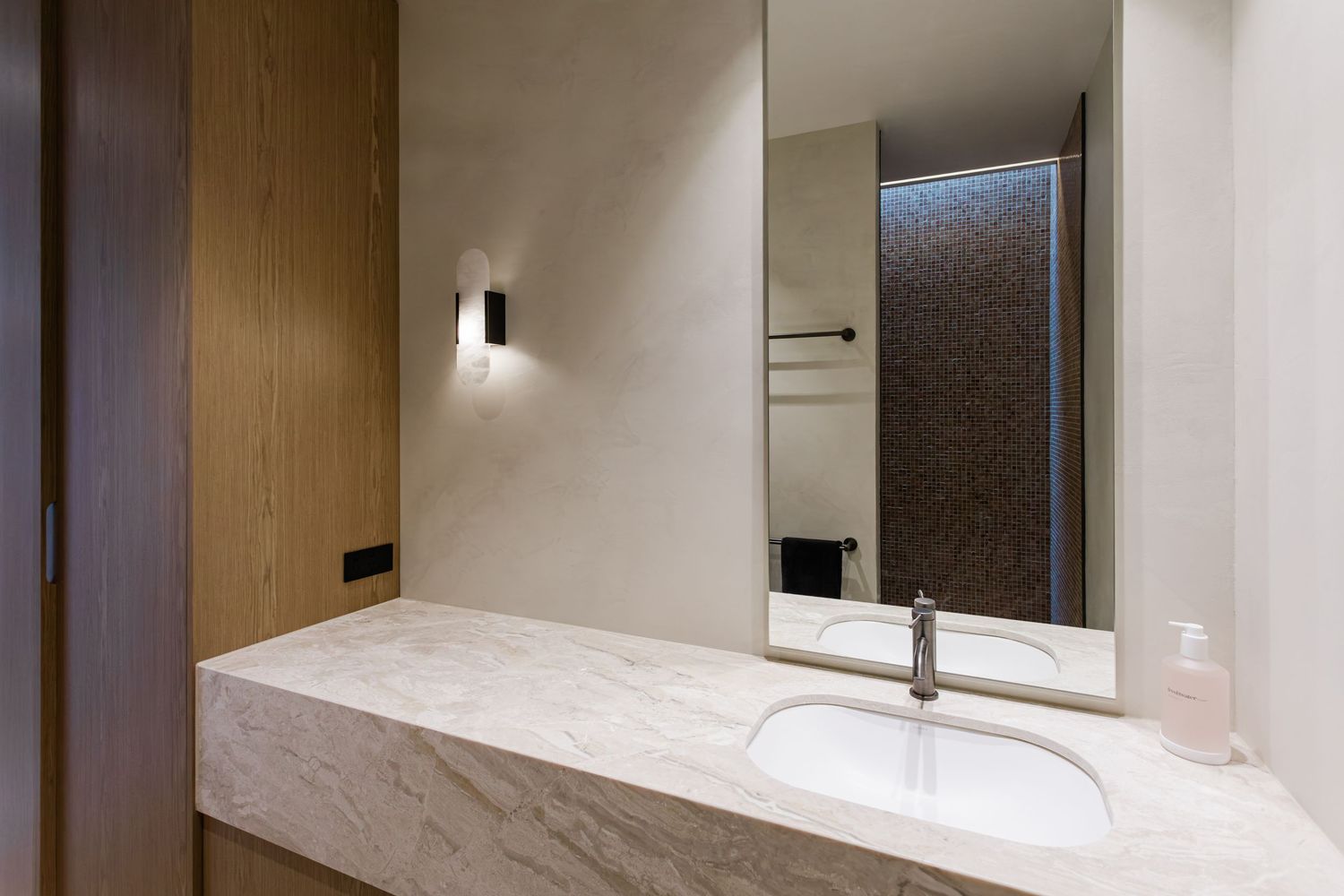 Modern bathroom interior with marble countertop, white cabinets and sleek chrome fixtures in a luxurious home setting.