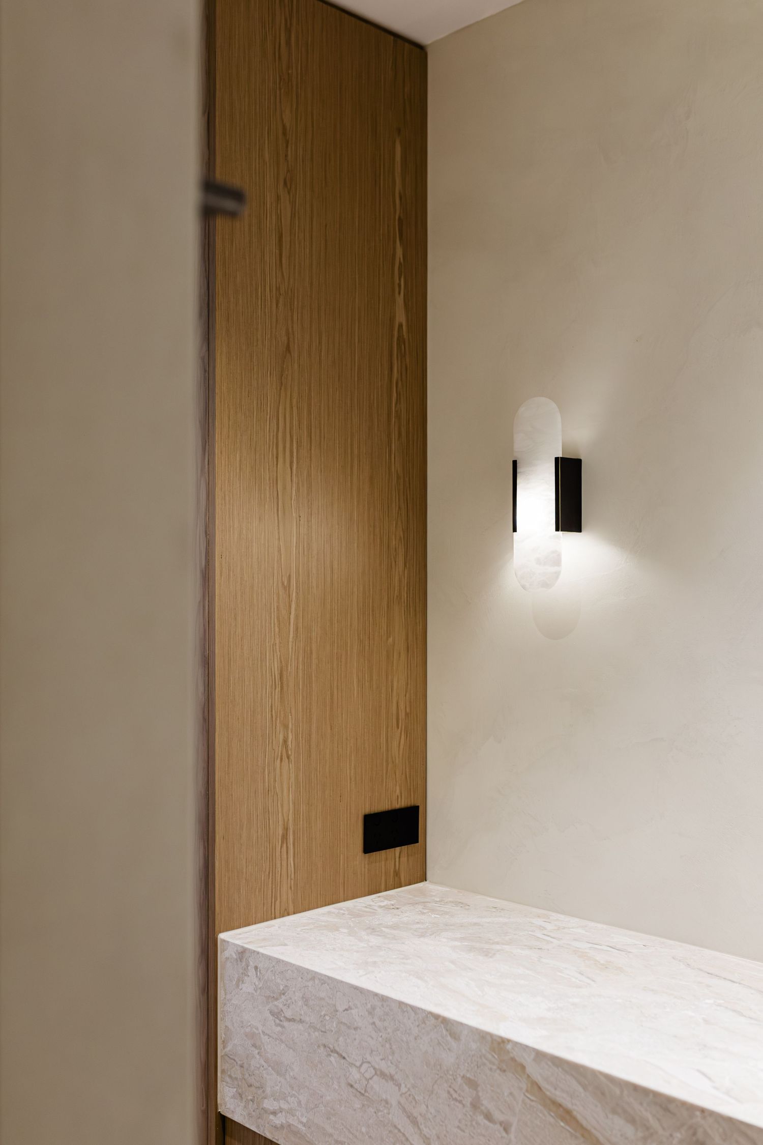 Modern minimalist room interior with wooden door and white walls featuring sleek wall-mounted lighting fixtures.