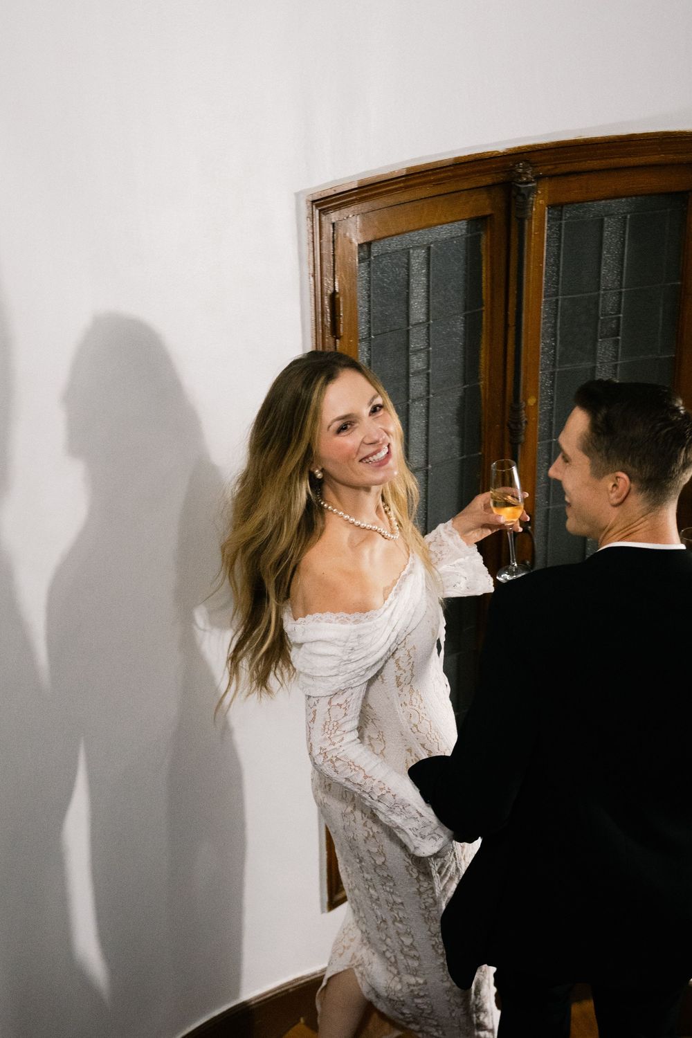 A couple in wedding attire dances together against a white wall, creating a series of dynamic movement shots.