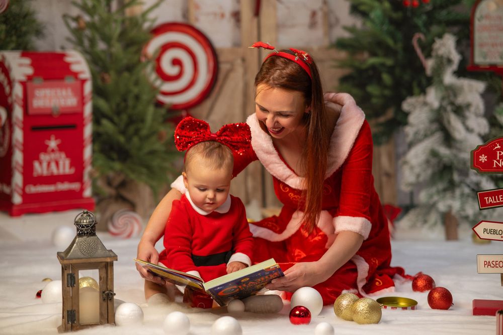 A cozy Christmas scene with people decorating and arranging festive holiday ornaments and decor near evergreen branches.