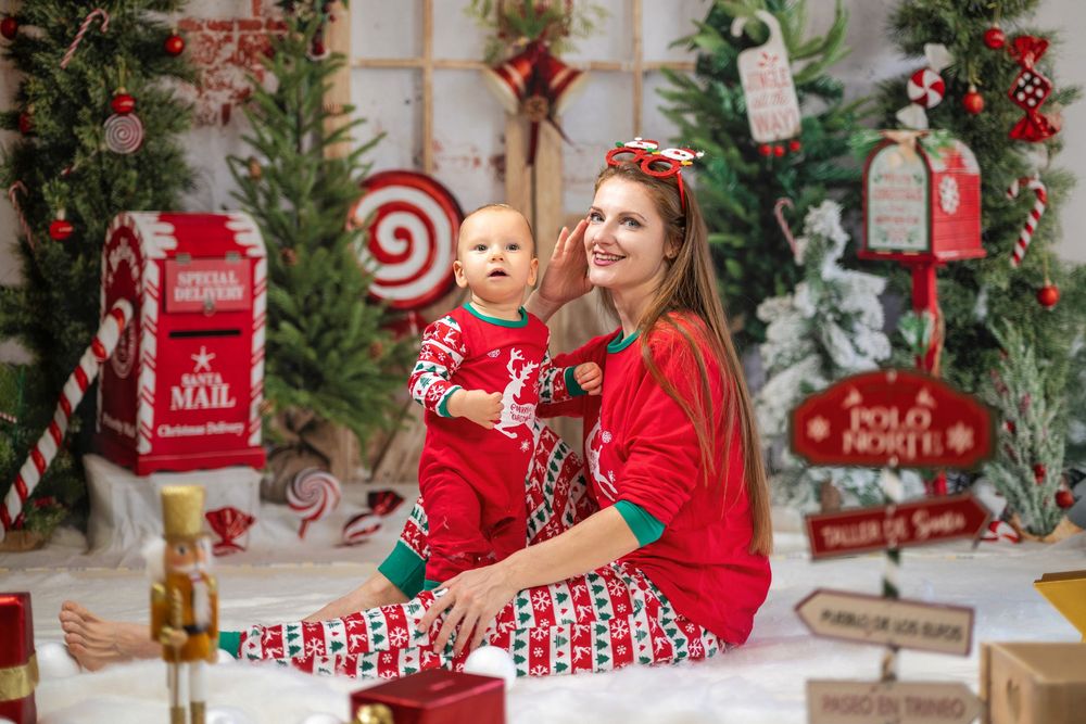 Holiday photo setup with red and white decorations, Christmas trees, and North Pole mailbox display.