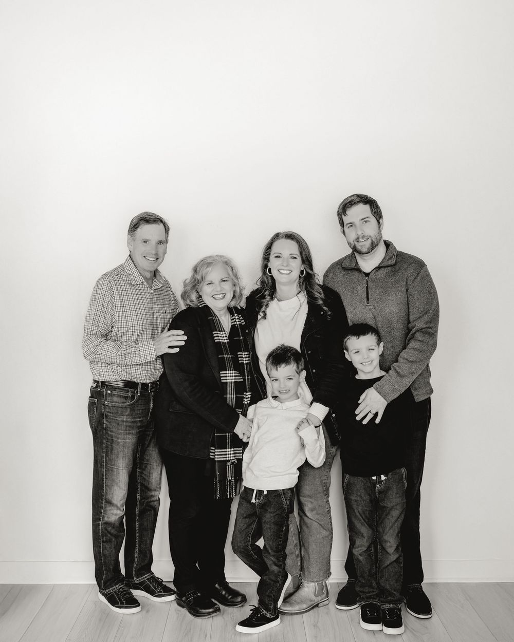 A sequence of black and white family portrait photos arranged horizontally showing different poses and groupings.