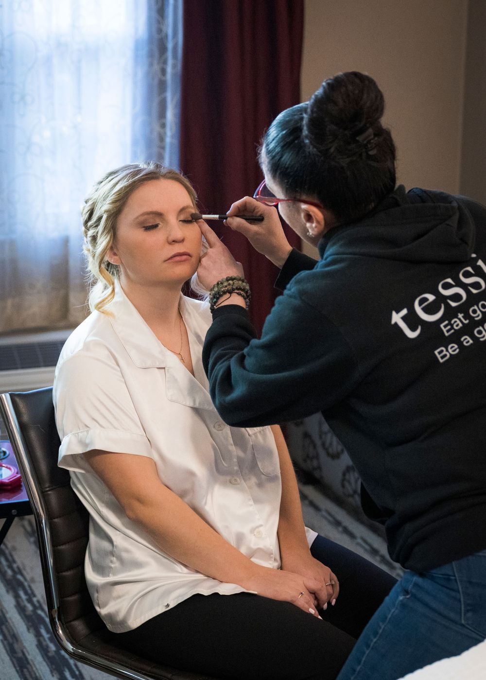 Behind the scenes preparation sequence showing styling and makeup application in natural window light.