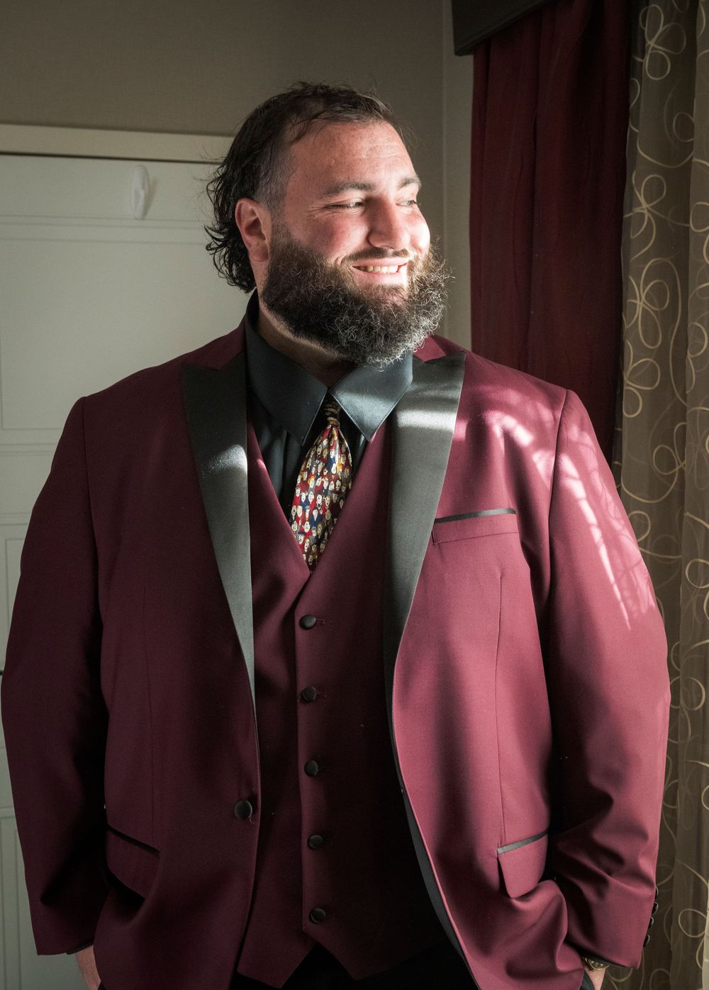 Multiple shots of a groomsman in a burgundy suit posing against a neutral background.