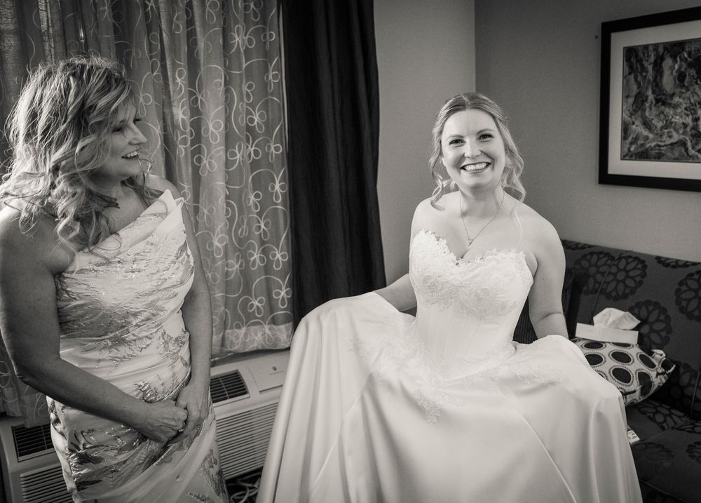 A series of getting ready moments showing a bride in a white lace wedding dress being helped with final preparations.