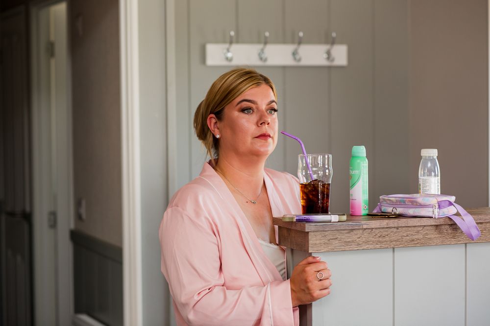 Wedding preparation scene with pink robes and delicate details in a bright interior setting.
