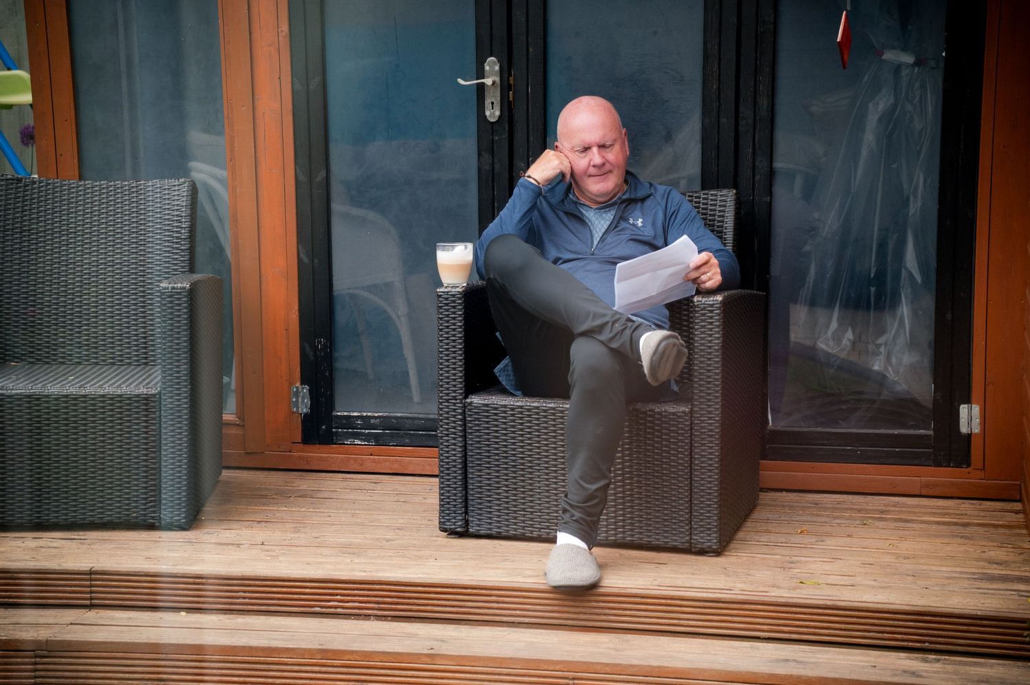 A person in a blue shirt sits on a wooden deck and looks to the right in a multi-panel sequence of images.