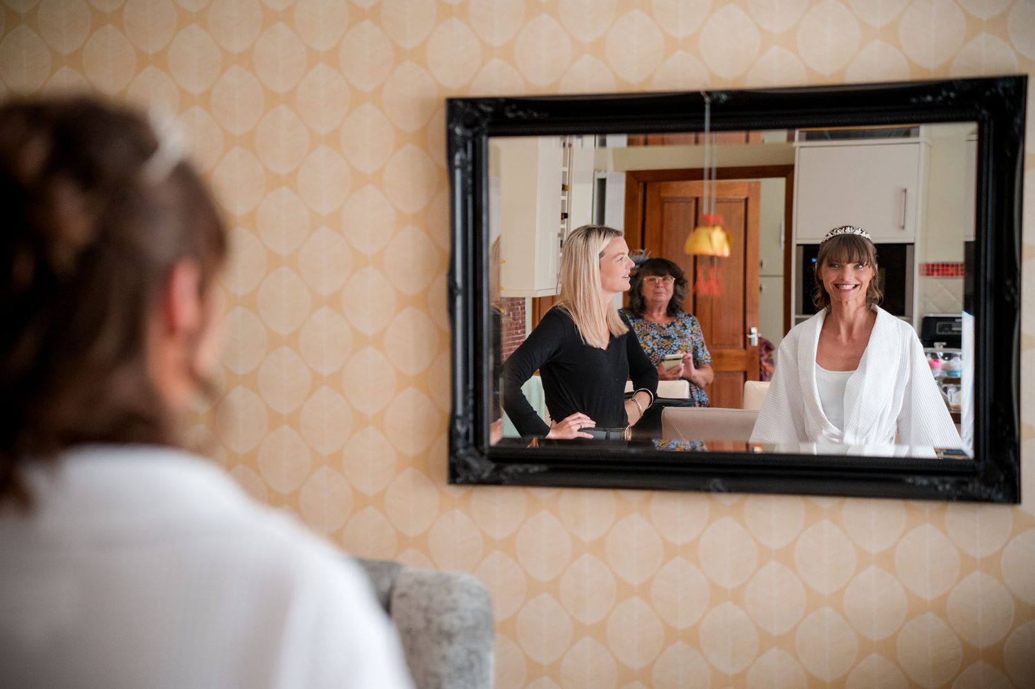 A series of framed mirrors on a wall reflect interior scenes in a salon or studio setting.
