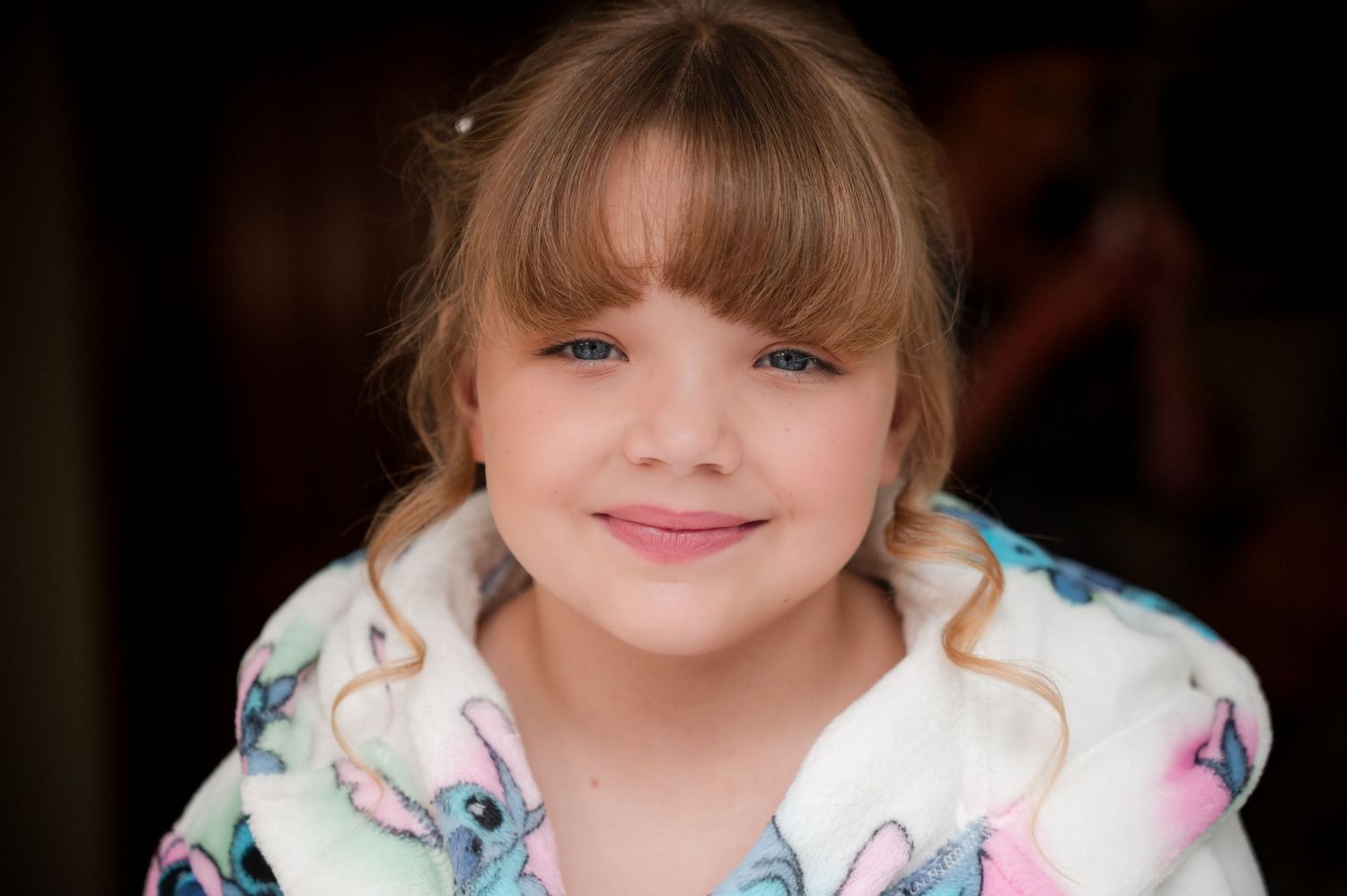 A series of eight connected photos showing a young child with curly hair wearing a floral dress and smiling at the camera.