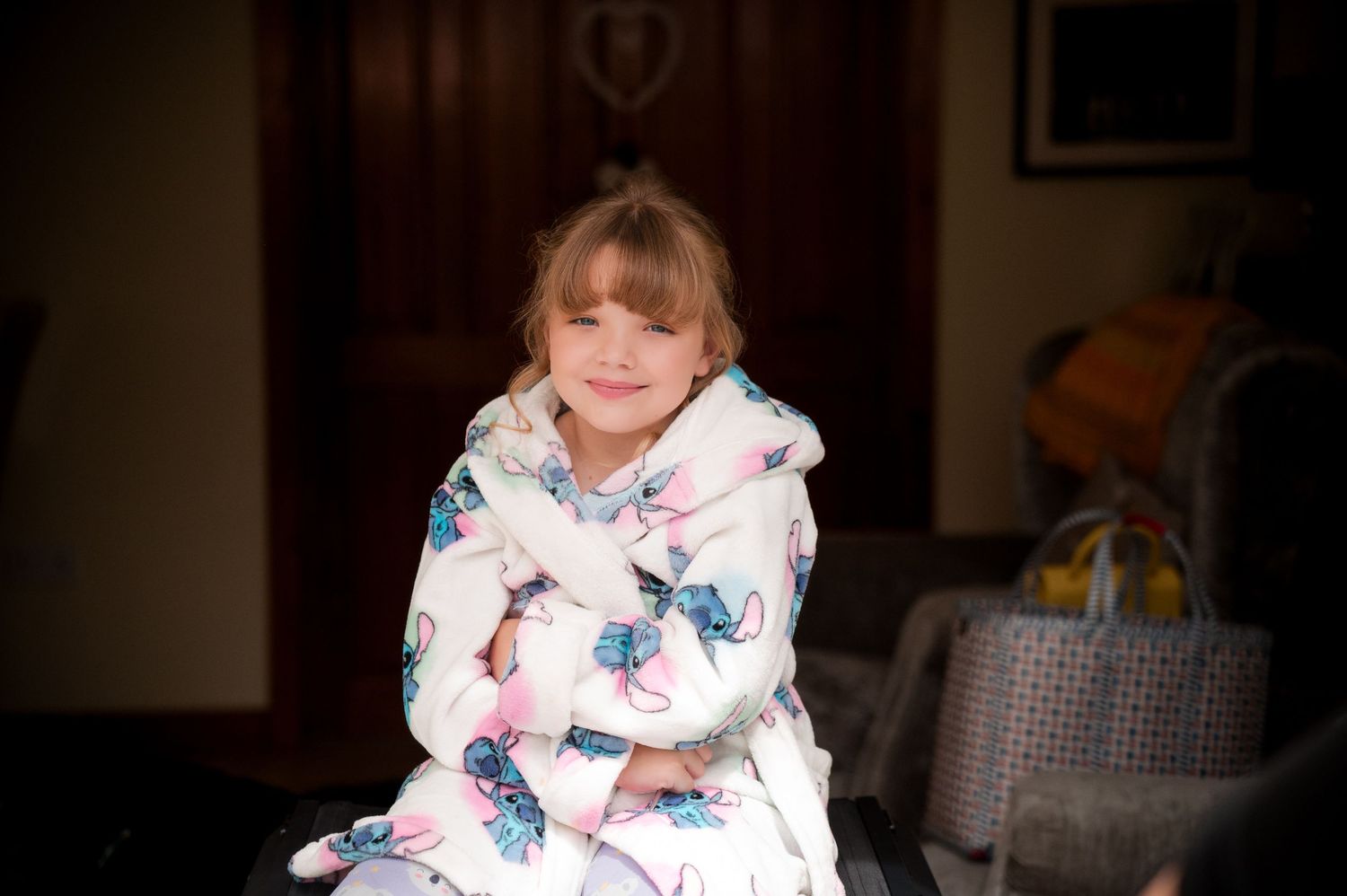 A person wearing a cozy butterfly-patterned bathrobe sits indoors.