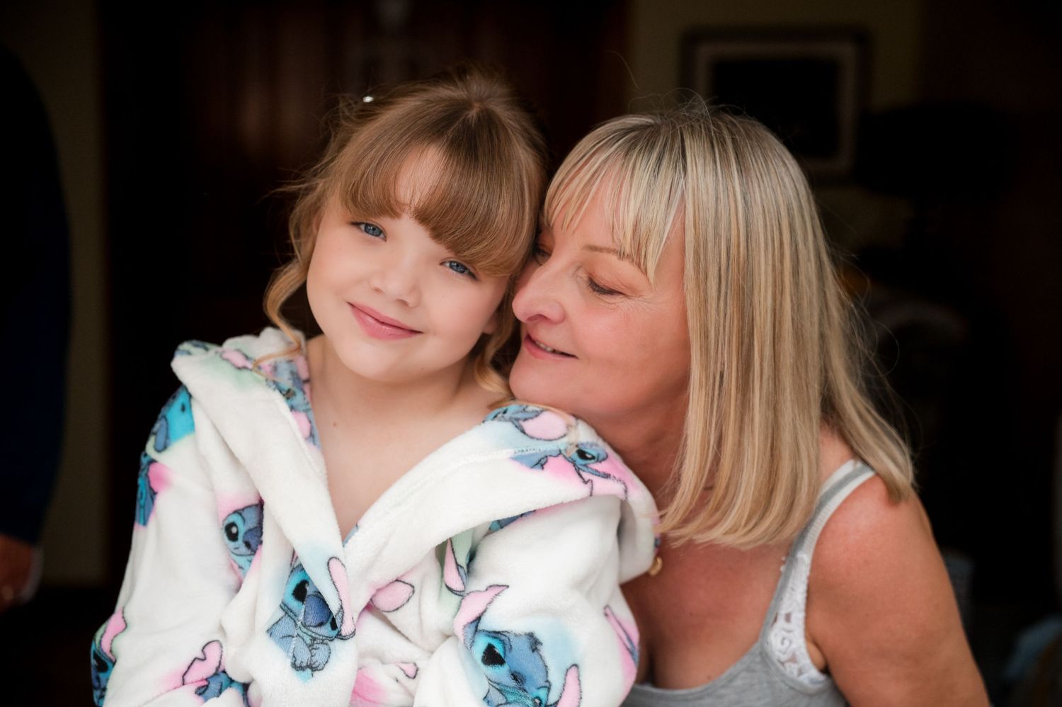 A parent and child share tender moments together in a series of loving poses against a dark background.