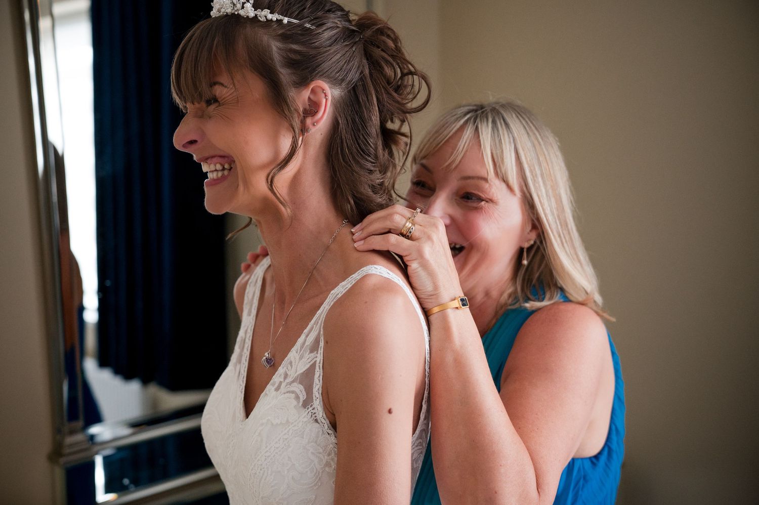 A group of women in formal attire share a joyful moment together during a special occasion.