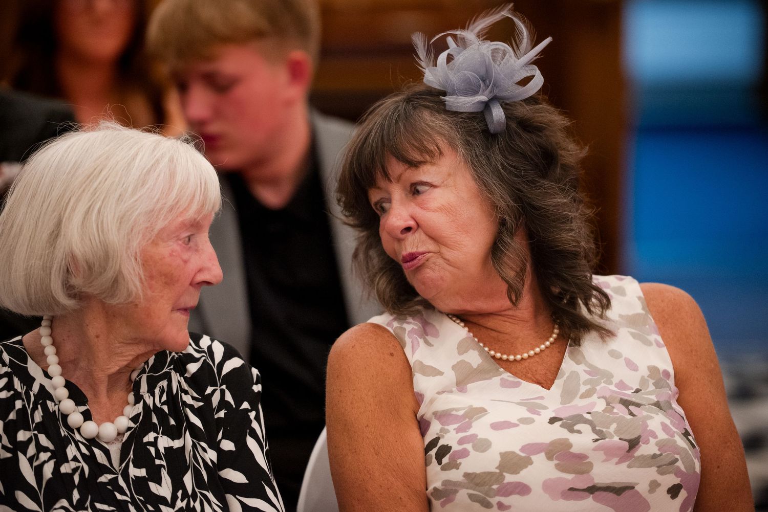 Guests at a wedding reception share emotional moments and laughter during a special celebration.