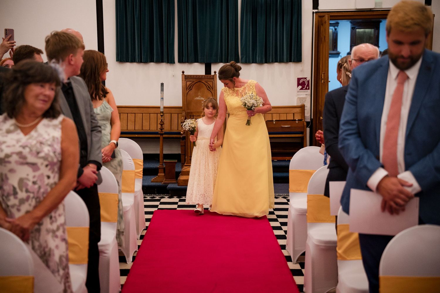 Wedding guests dance and celebrate together on a wooden dance floor during a reception celebration.