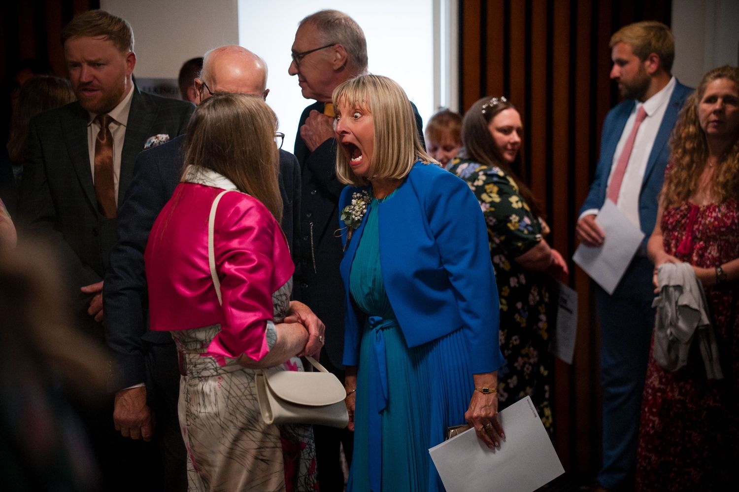 People in formal attire gather and interact during what appears to be a professional event or reception.