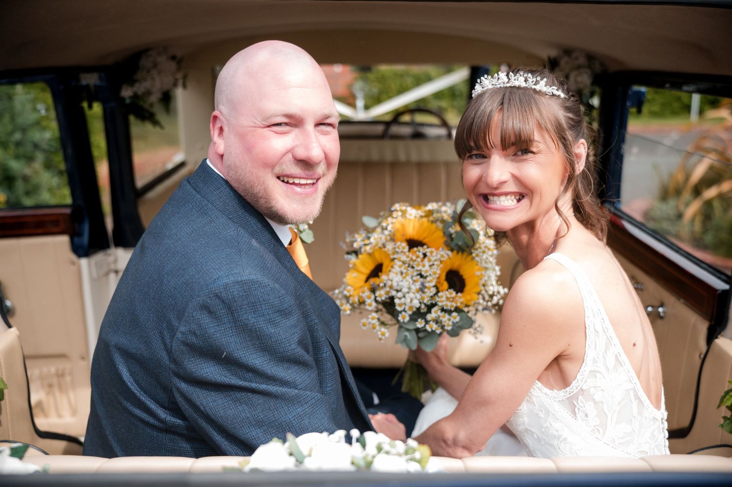 A bride and groom share intimate moments in a car during their wedding celebration.