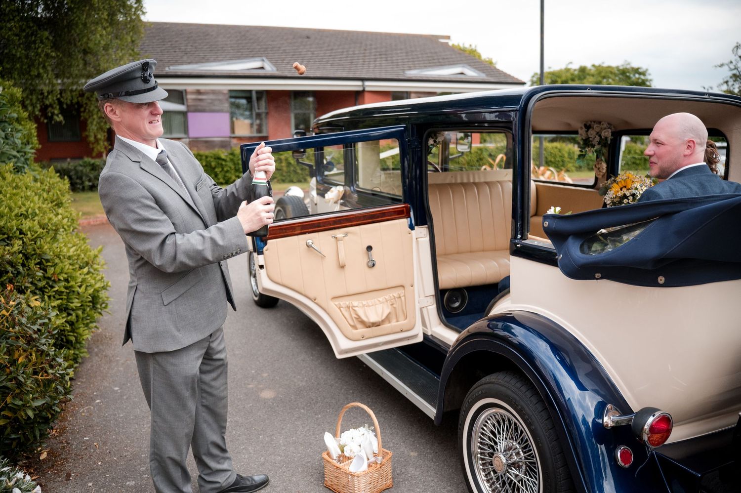 Classic vintage car collection displayed at an outdoor event with people admiring the elegant vehicles.