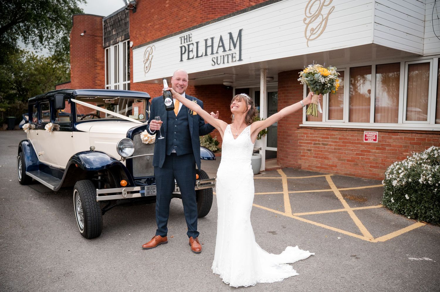 A group of people walking through a brick building entrance with Pelham signage visible.