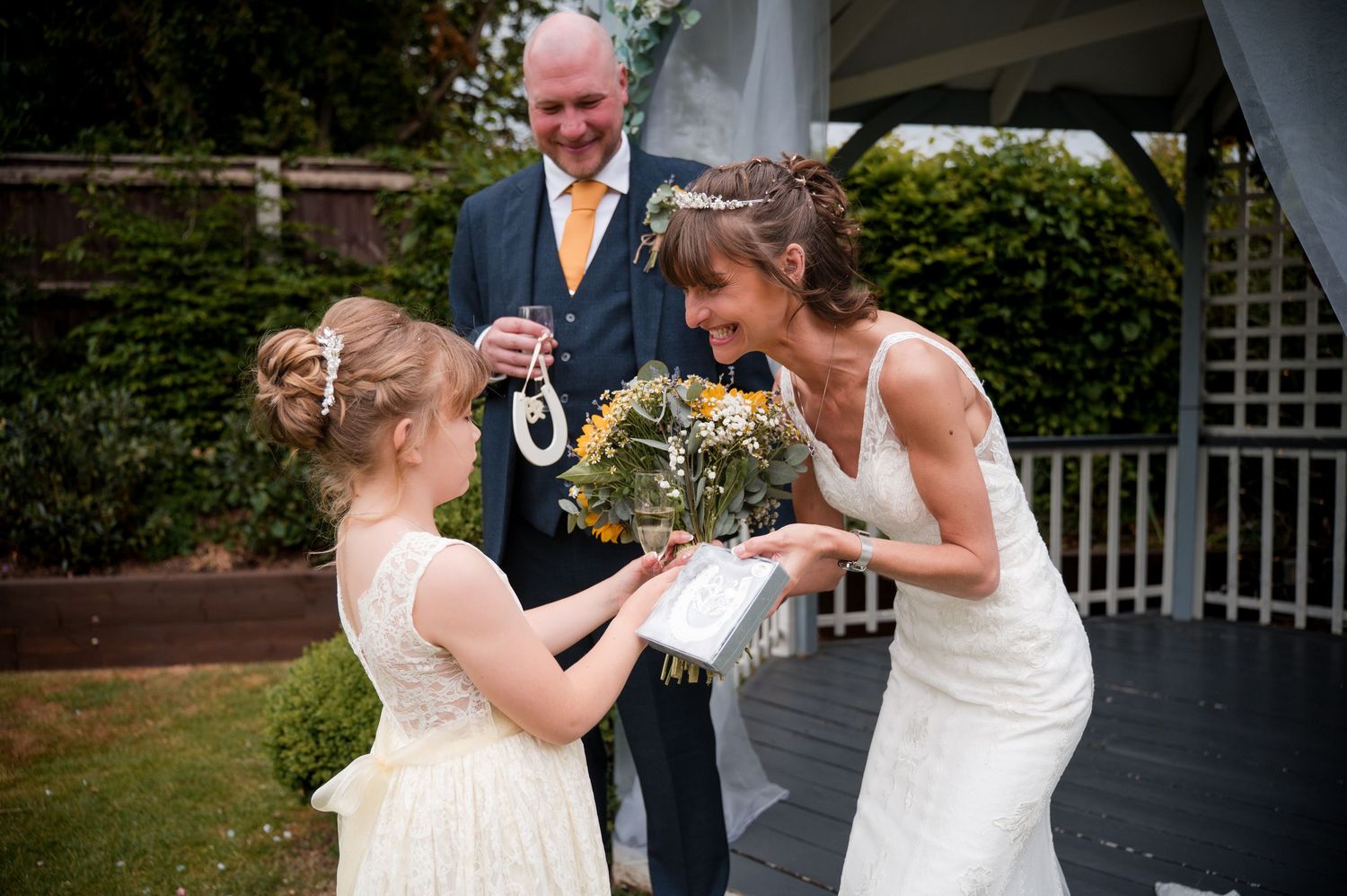 Wedding party shares joyful laughter during outdoor garden celebration.