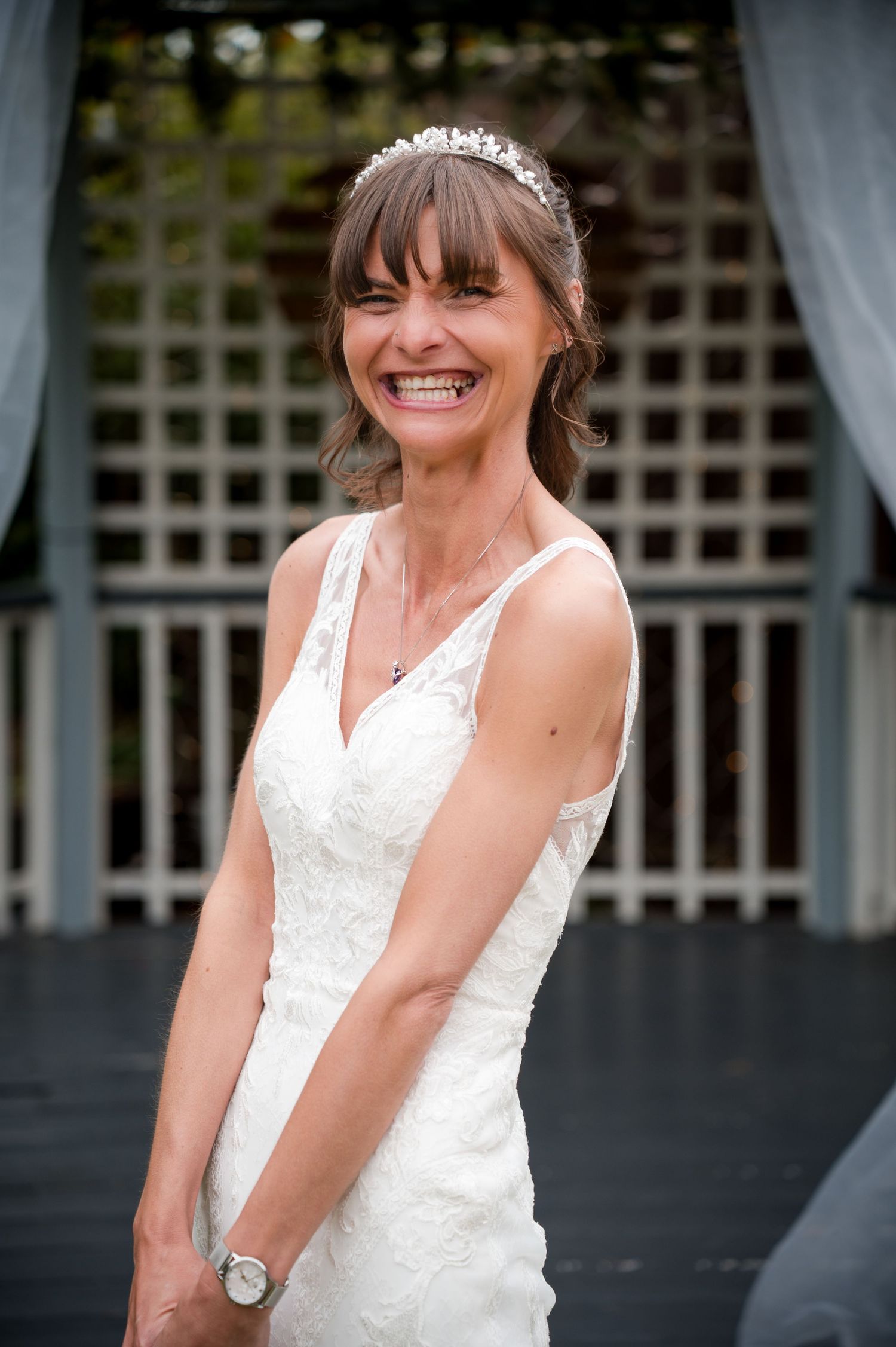 A joyful bride in a white lace wedding dress laughs candidly in a series of four connected photos.